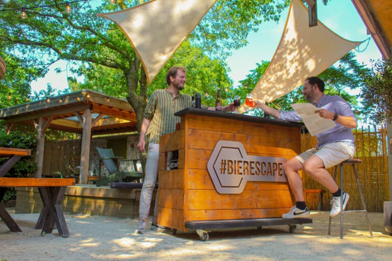 Gasten genieten van een biertje op het zonnige terras na het spelen van de escape room in Zwolle